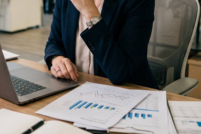 אישה ליד מחשב עם דוחות.