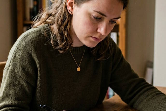 אישה כותבת בשולחן עבודה.